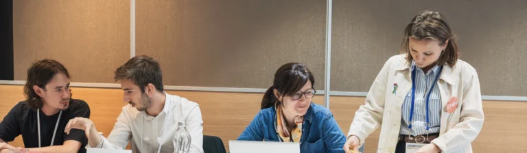 Quatre personnes travaillent ensemble autour d'une table lors d'un atelier